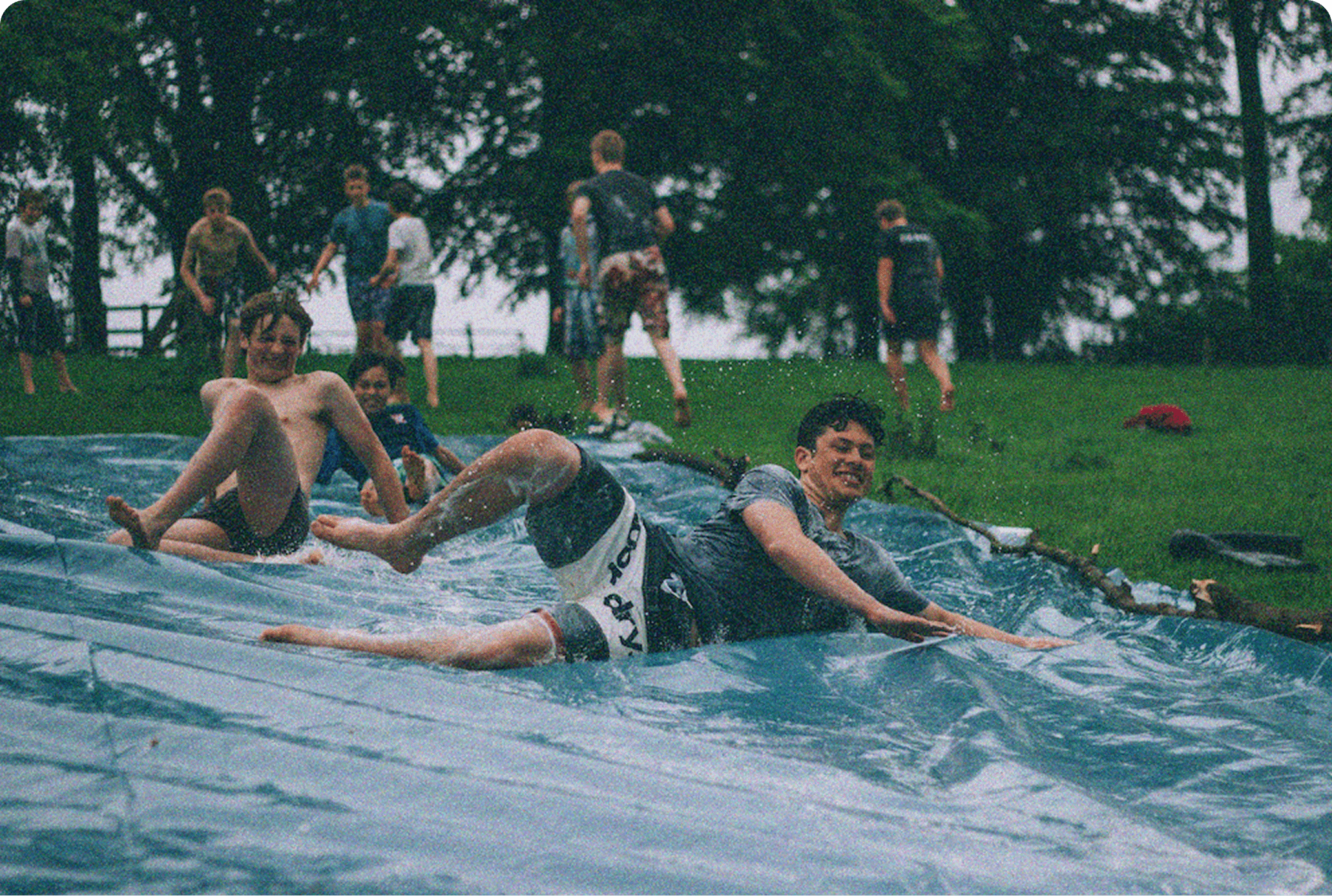 Friends having fun on a slip and slide